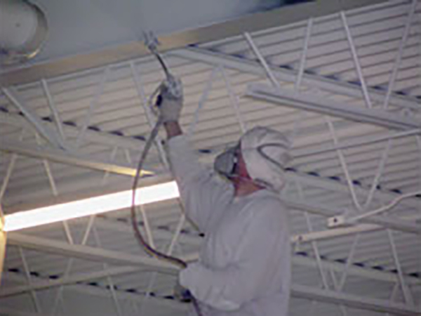 spraying paint on warehouse ceiling